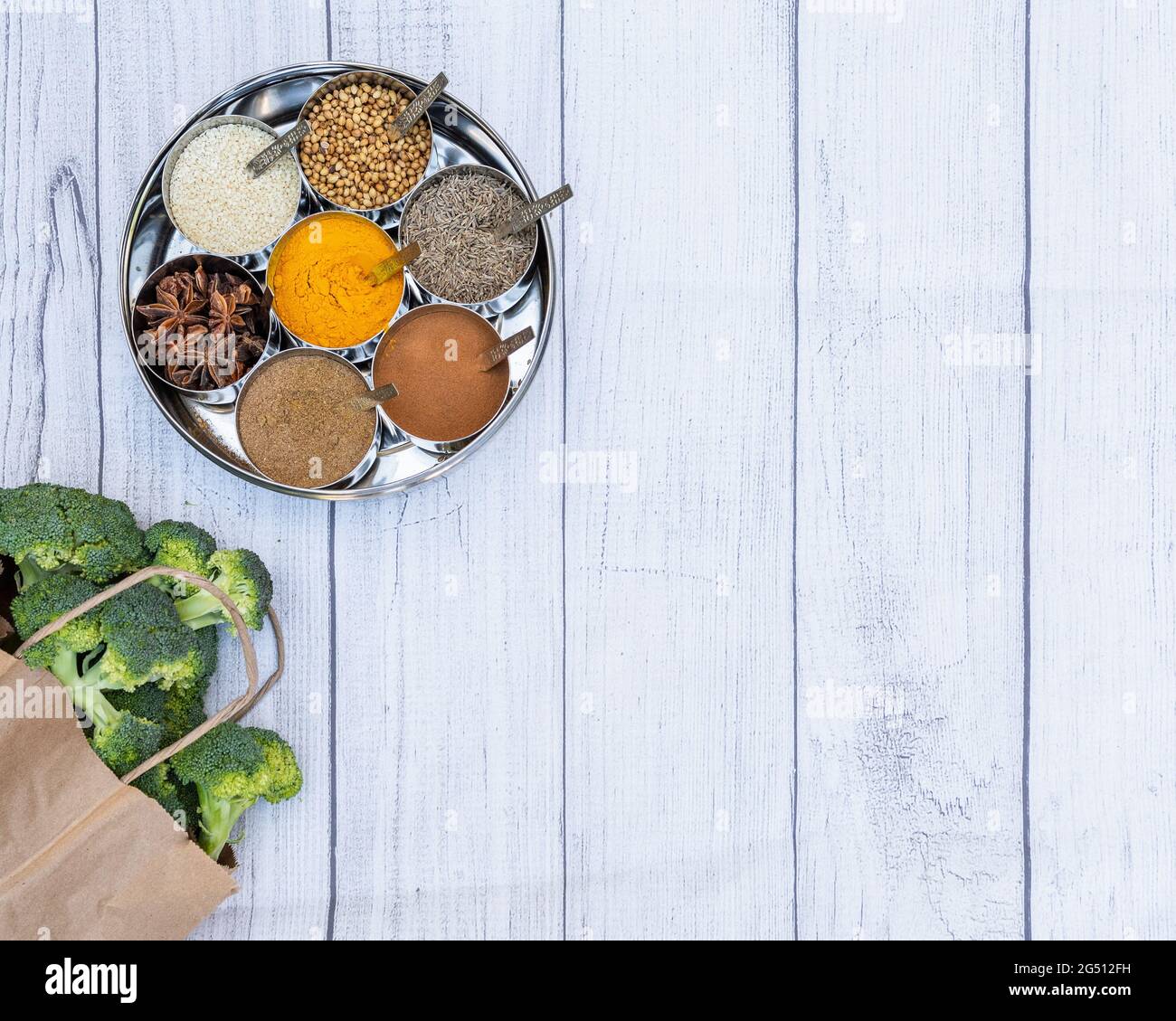 Flaches Lay von indischen Gewürzen mit einer Tüte Brokkoli und Platz zum Kopieren. Stockfoto