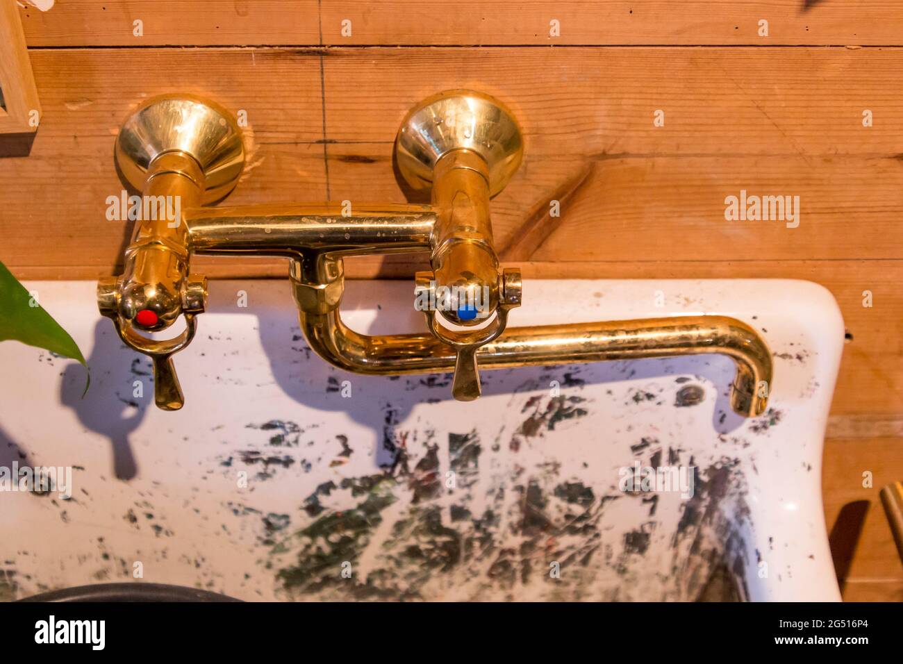 Goldfarbene Wasserhähne über einem weißen Waschbecken, Stockfoto