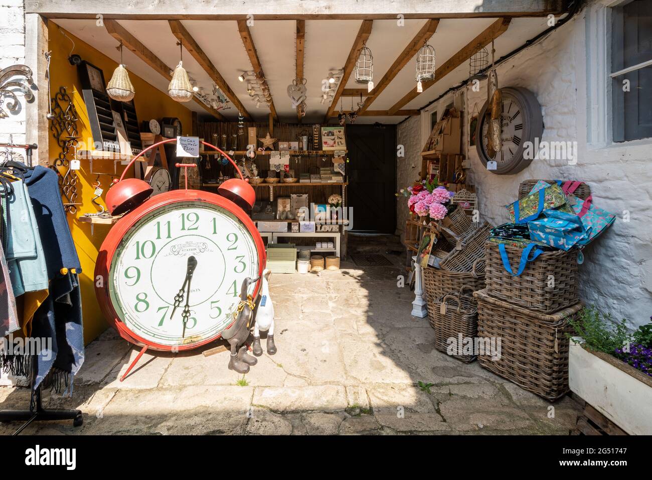 Souvenirladen in Lacock Village, Wiltshire, England, mit skurrilen großen Weckers und einer Vielzahl von Souvenirs und Geschenken Stockfoto