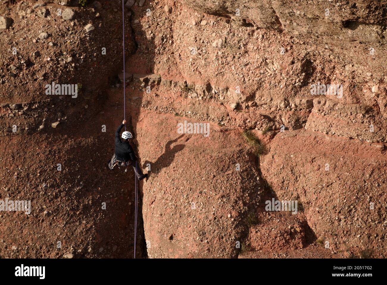 Ein Bergsteiger, der den Felsen Cavall Bernat in Matadepera, in Sant Llorenç del Munt i l'Obac (Barcelona, Katalonien, Spanien), erklimmen hat Stockfoto