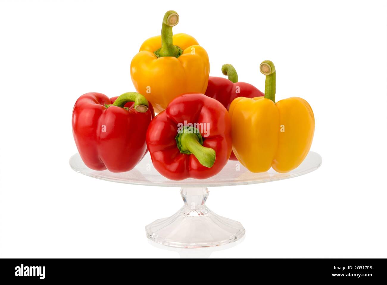 Rote und gelbe Paprika auf klarem Glas erhöhte Platte isoliert auf weißem Hintergrund Stockfoto