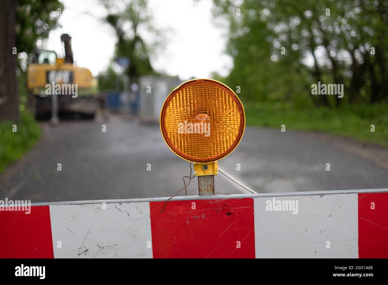 Verkehrssicherheits- und Warnleuchte - Straßensperre mit orangefarbenem Licht. Detail und Nahaufnahme der Barriere, um den Verkehr aufgrund von Straßenbau zu stoppen. Kein Zutritt Stockfoto