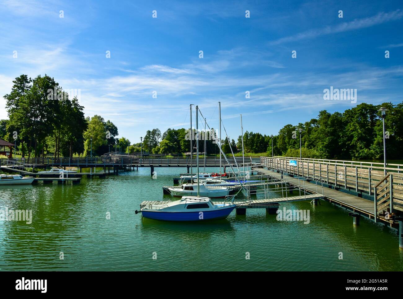 Kleine Boote in einer Bucht am Pier, die an einem sonnigen Tag auf einem See schweben Stockfoto