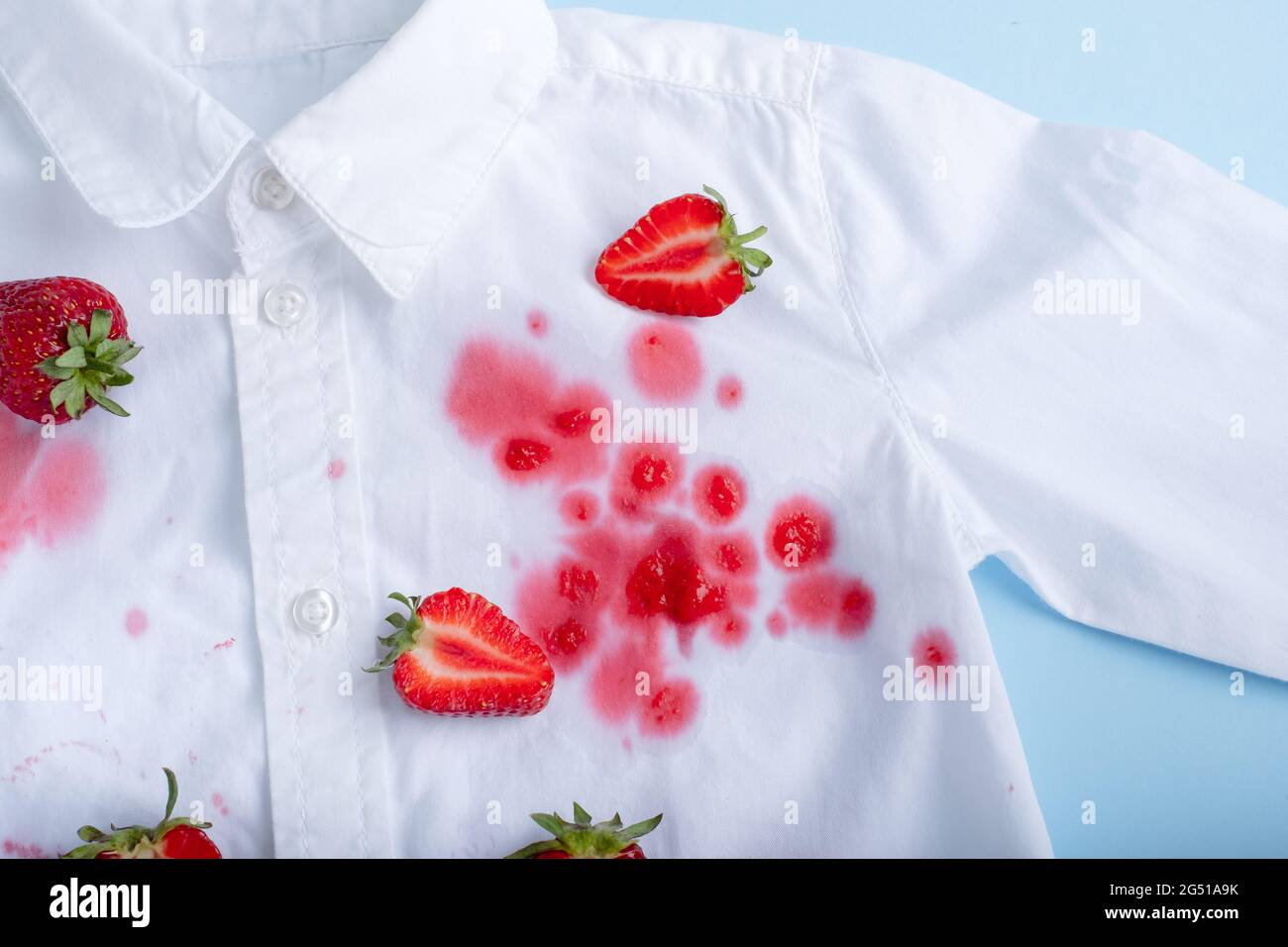 Komplexer Erdbeerfleck auf einem weißen Hemd. Isoliert Stockfoto
