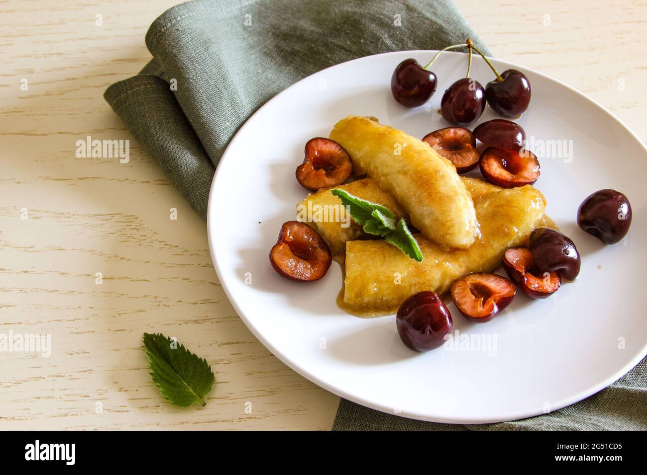 Hausgemachte karamellisierte Banane auf weißem Teller. Veganes Dessert. Amerikanisches Gericht. Stockfoto