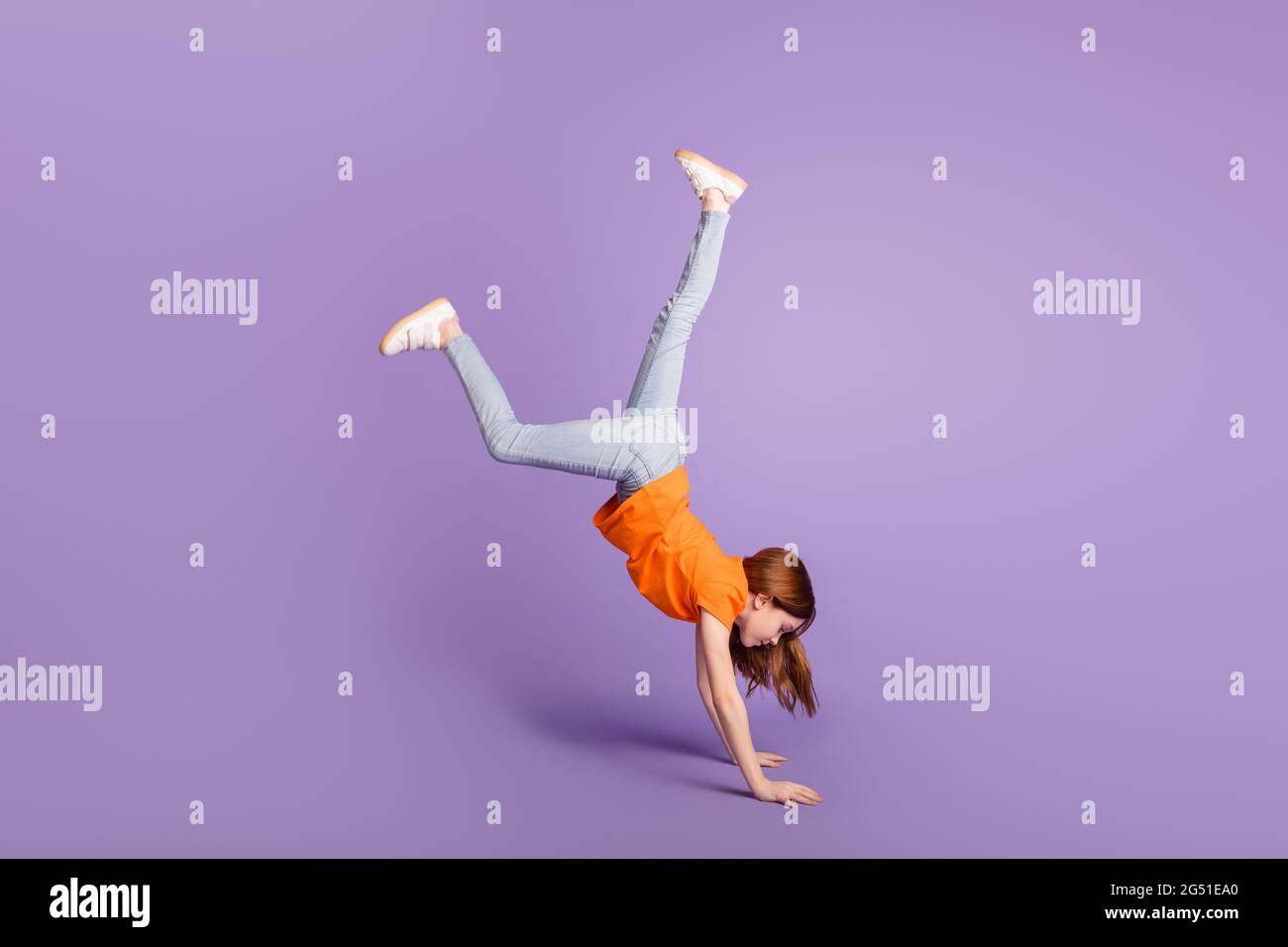 In voller Länge Körpergröße Ansicht der attraktiven flexiblen Mädchen stehen zu Fuß auf Händen Spaß isoliert über violett lila Farbe Hintergrund Stockfoto