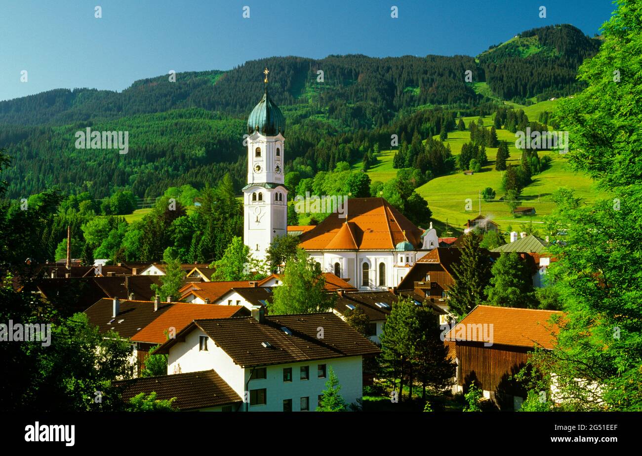 Dorf mit Kirche und Bergen im Hintergrund, Nesselwang, Bayern, Deutschland Stockfoto