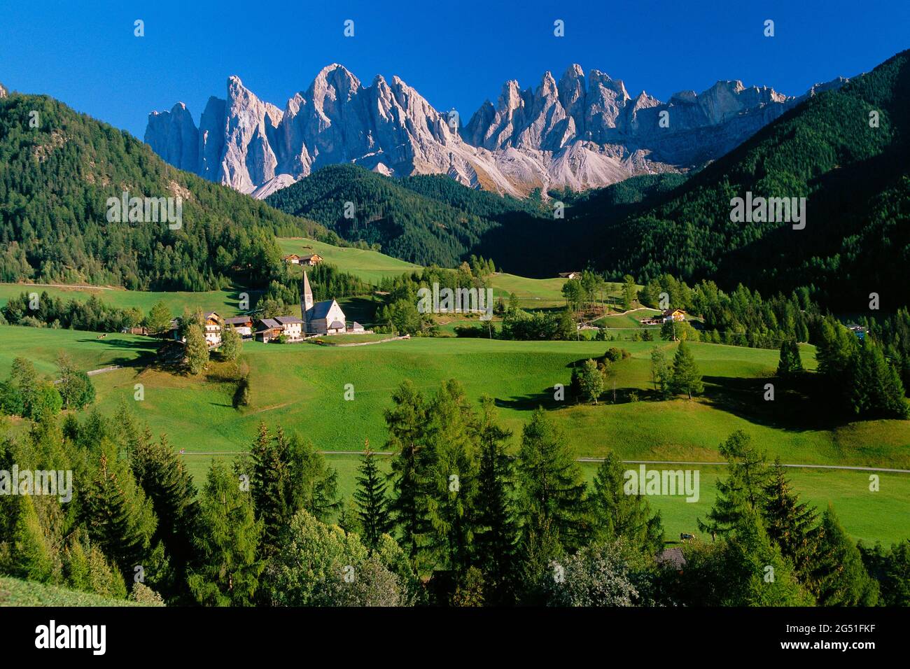 Blick auf Kirche im Tal und Berge dahinter, St. Magdalena, Dolomiten, Italien Stockfoto