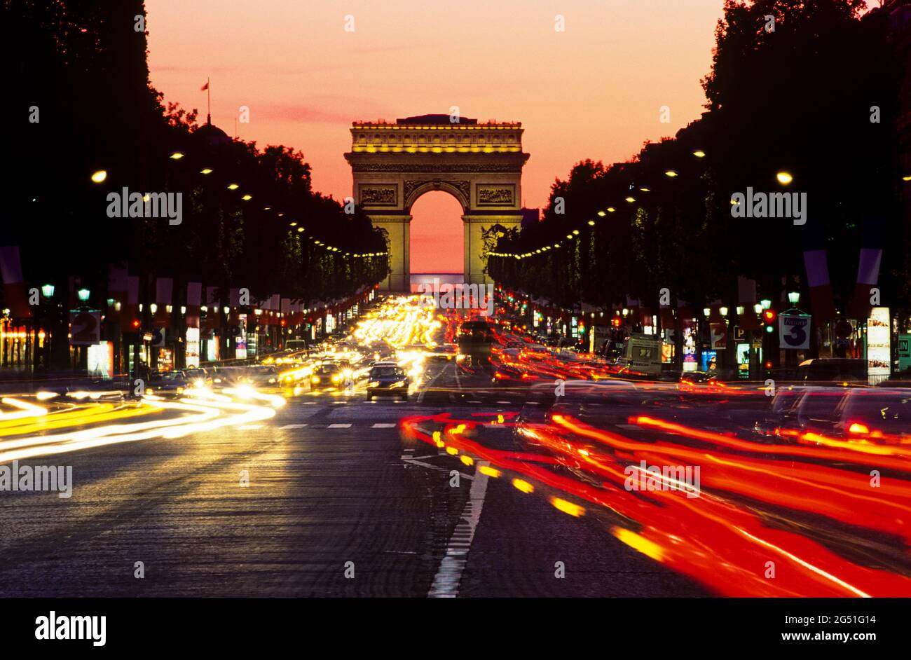 Blick auf die Straße bei Nacht mit Triumphbogen dahinter, Paris, Frankreich Stockfoto