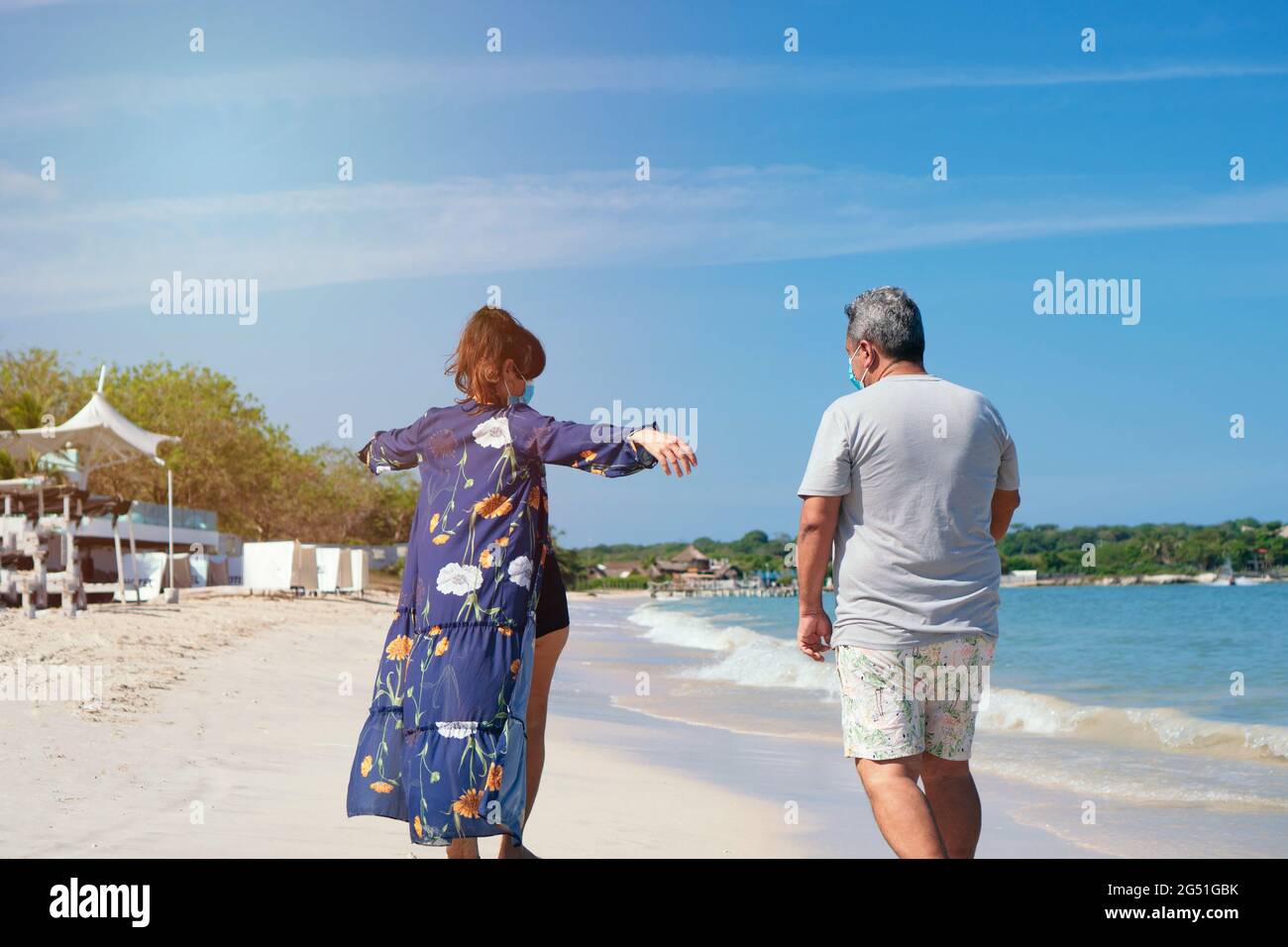Ein älteres Paar, das gemeinsam am Strand spazieren geht Stockfoto