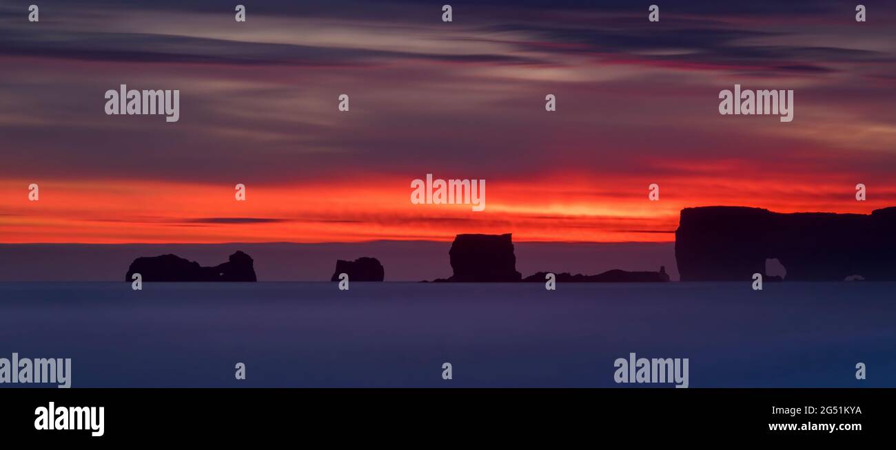 Landschaft mit Meeresstapeln bei Sonnenuntergang, Halbinsel Dyrholaey, Island Stockfoto