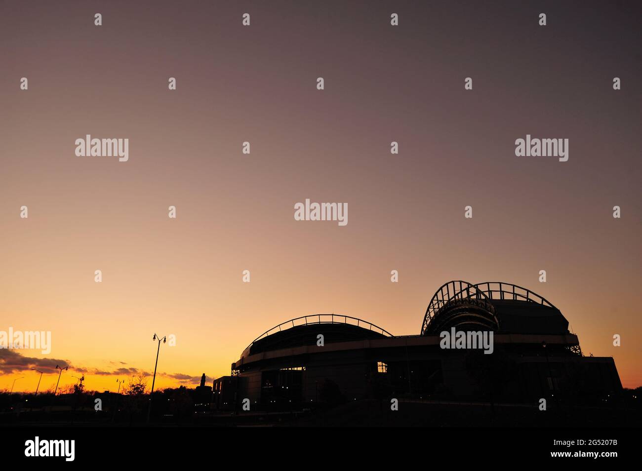 Milwaukee, Wisconsin, USA. Die untergehende Sonne taucht unter den Horizont und registriert einen Schein jenseits des Miller Park, der Heimat der Milwaukee Brewers. Stockfoto