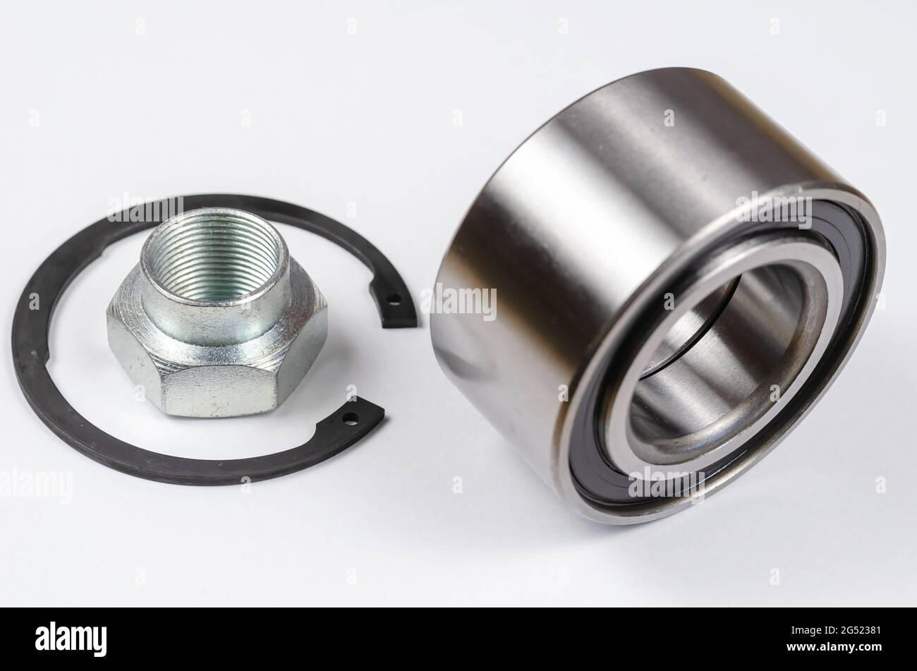 Satz von Autoteilen auf weißem Hintergrund. Neuer Sicherungsring, Sondermutter und Nabenlager. Ersatzteile, Verbrauchsmaterialien. Stockfoto