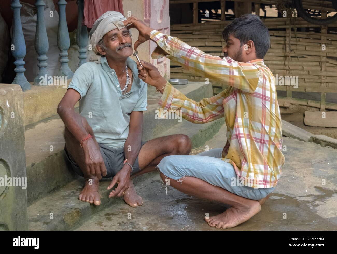 Erstaunliche Foto zeigt Vater Sohn Beziehung der Liebe und Fürsorge in der Familie. Der junge Sohn hilft seinem Vater mittleren Alters, indem er zu Hause einen Salondienst leistet. Stockfoto