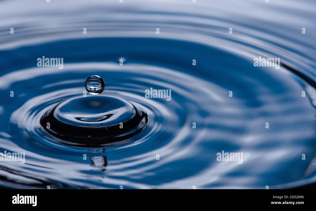 Wassertropfen spritzt auf blau. Stockfoto