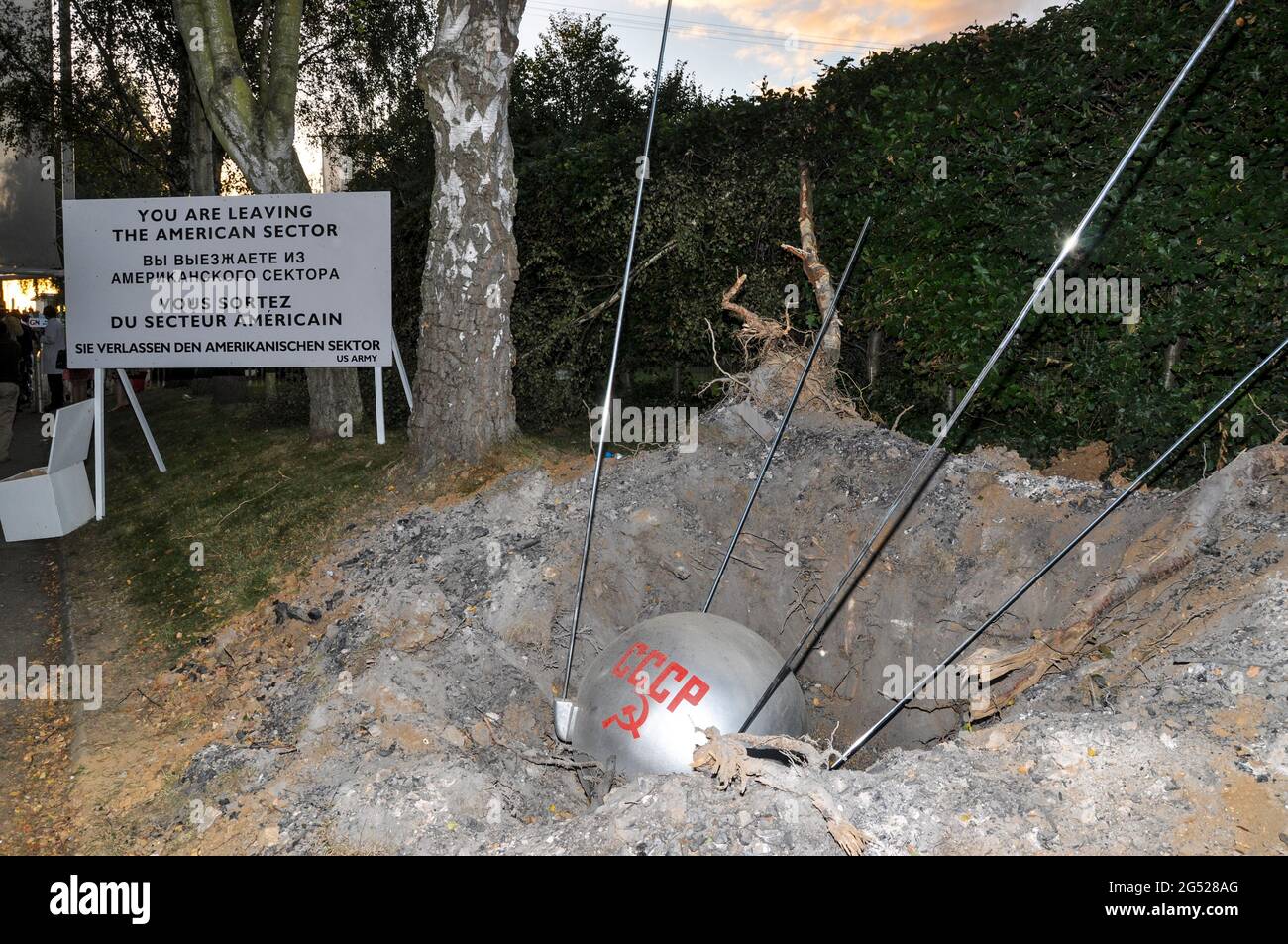 Humorvolles Diorama beim Goodwood Revival 2012, das die Ost-West-Grenze mit einem mit CCCP markierten Sputnik 1-Satelliten darstellt, der zur Erde abgestürzt ist Stockfoto