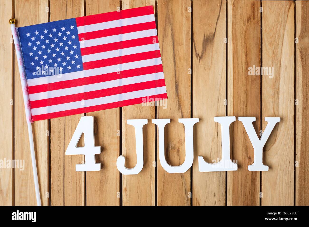 Text des 4. Juli und Flagge der Vereinigten Staaten von Amerika auf Holztisch Hintergrund. USA Unabhängigkeitsfeiertag und Festungskonzepte Stockfoto