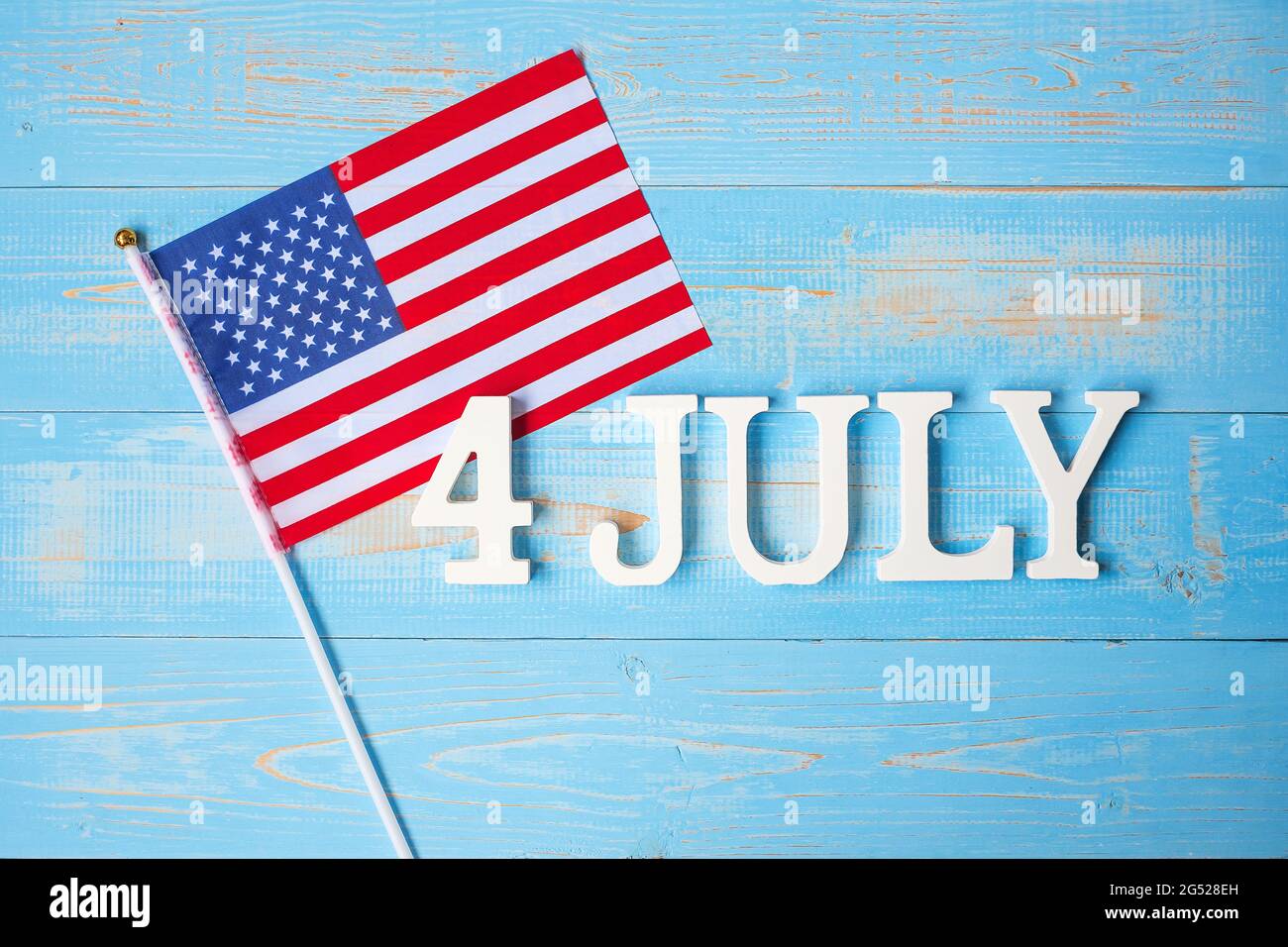 Text des 4. Juli und Flagge der Vereinigten Staaten von Amerika auf Holztisch Hintergrund. USA Unabhängigkeitsfeiertag und Festungskonzepte Stockfoto