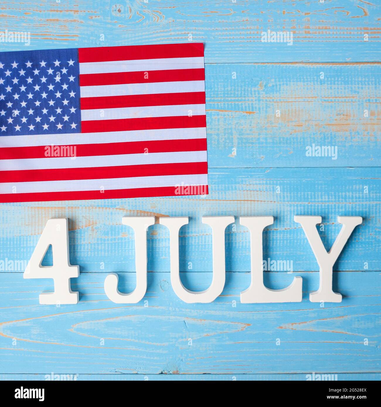 Text des 4. Juli und Flagge der Vereinigten Staaten von Amerika auf Holztisch Hintergrund. USA Unabhängigkeitsfeiertag und Festungskonzepte Stockfoto
