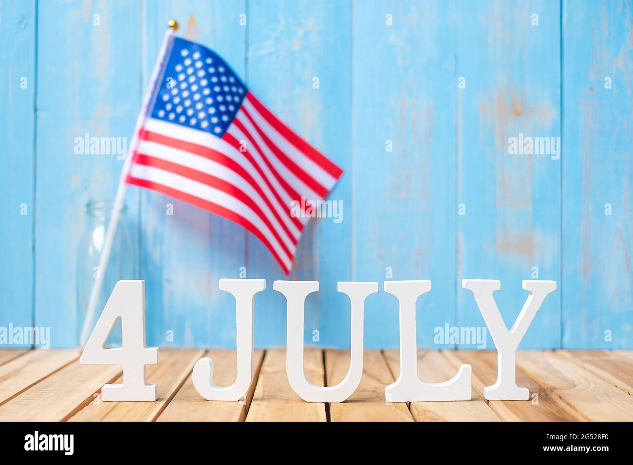 Text des 4. Juli und Flagge der Vereinigten Staaten von Amerika auf Holztisch Hintergrund. USA Unabhängigkeitsfeiertag und Festungskonzepte Stockfoto