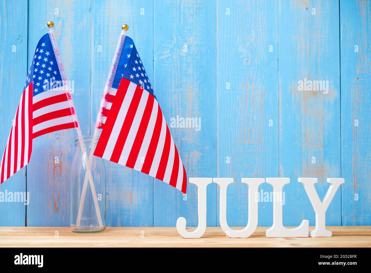 Juli Text und Flagge der Vereinigten Staaten von Amerika auf Holztisch Hintergrund. USA Unabhängigkeitsfeiertag und Festungskonzepte Stockfoto