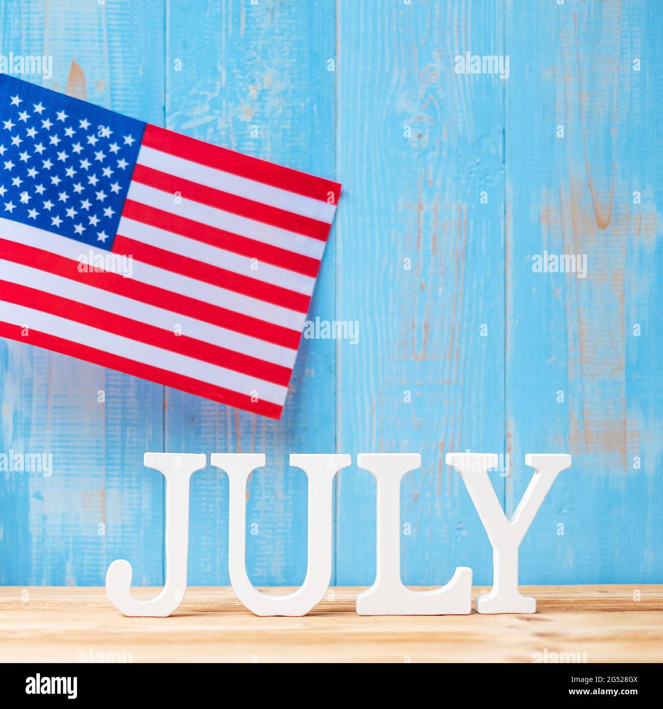 Juli Text und Flagge der Vereinigten Staaten von Amerika auf Holztisch Hintergrund. USA Unabhängigkeitsfeiertag und Festungskonzepte Stockfoto