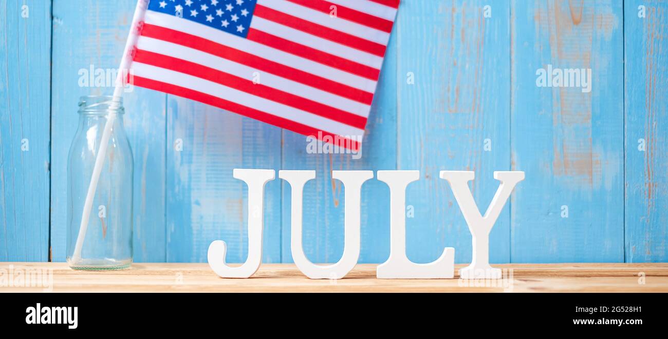 Juli Text und Flagge der Vereinigten Staaten von Amerika auf Holztisch Hintergrund. USA Unabhängigkeitsfeiertag und Festungskonzepte Stockfoto