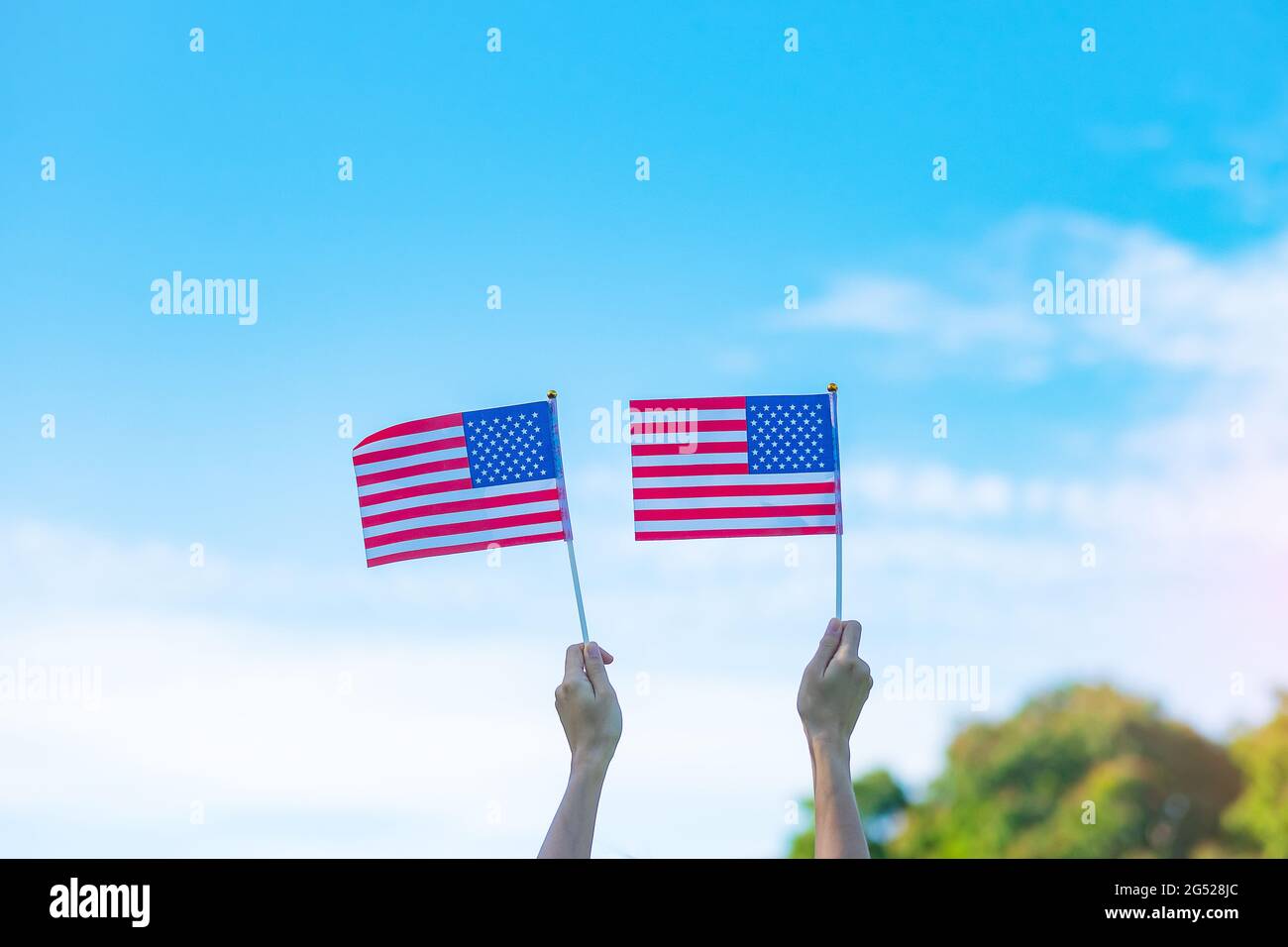 Hand hält die Flagge der Vereinigten Staaten von Amerika auf blauem Himmel Hintergrund. USA: Feiertag der Veteranen, Gedenkstätte, Unabhängigkeit (4. Juli) und Labor Day con Stockfoto