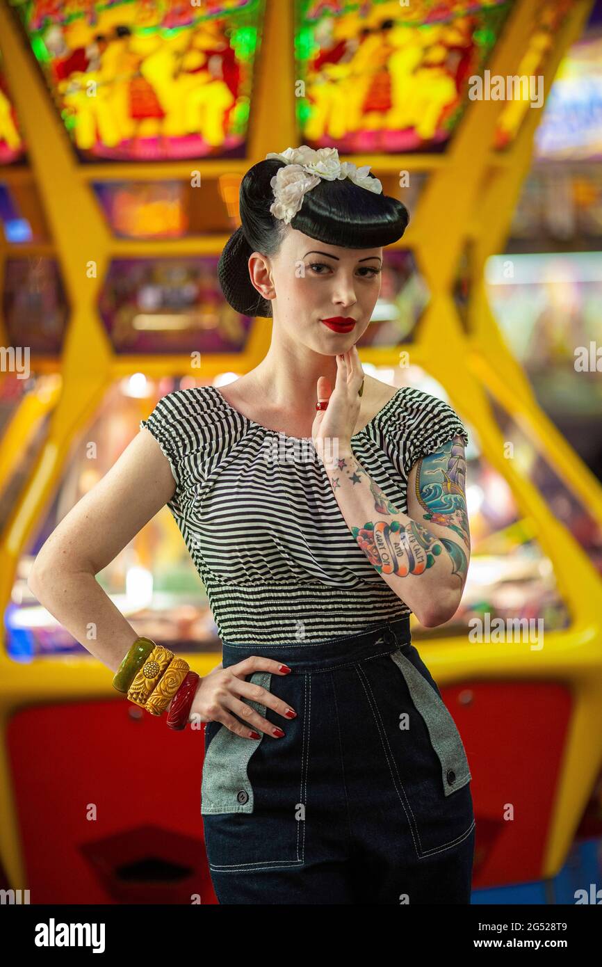Rockabilly Girl posiert mit ihren Tattoos während des Rhythm Riot Weekend in Camber Sands, Großbritannien Stockfoto