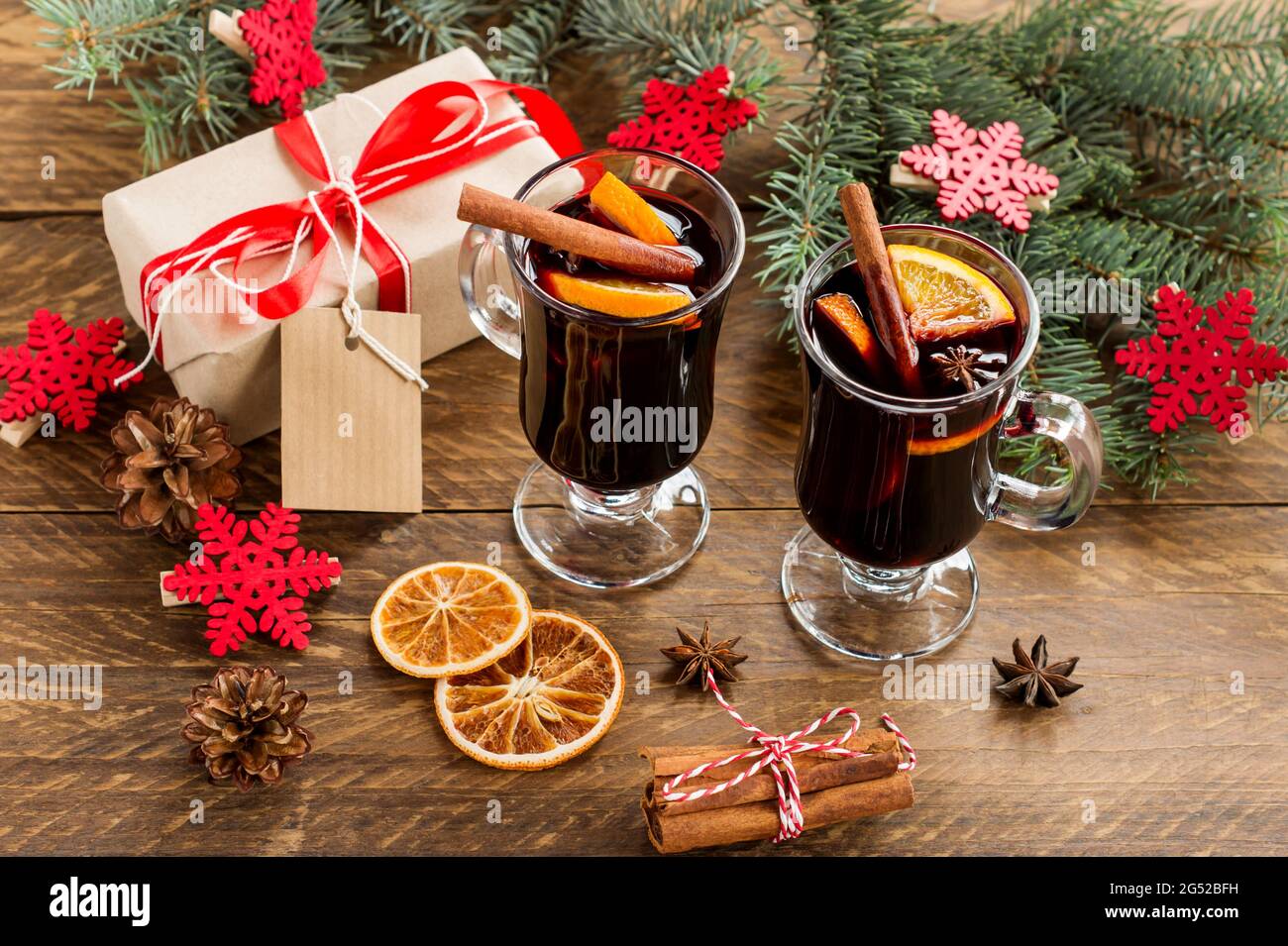 Weihnachtlicher Glühwein mit Gewürzen und Orangen auf einem rustikalen ...