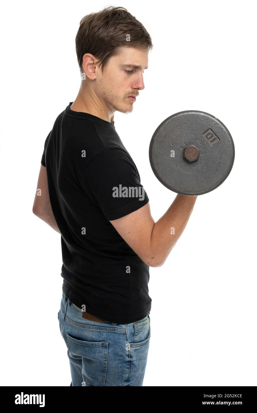 Junger, hübscher, großer, schlanker weißer Mann mit brauner Hantel in schwarzem Hemd in blauer Jeans, isoliert auf weißem Hintergrund Stockfoto