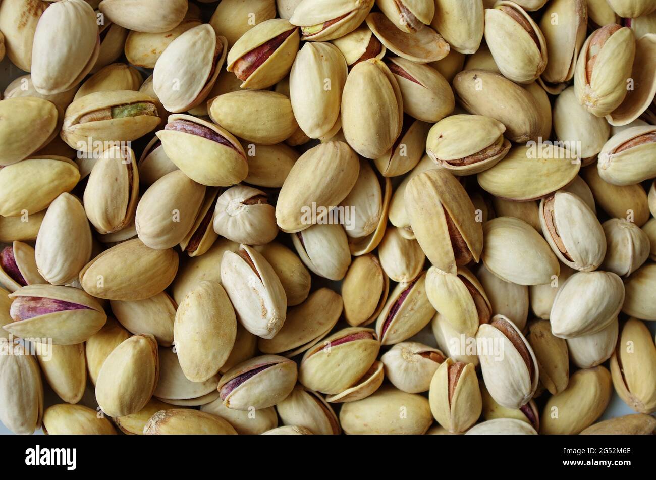 Haufen Pistazien in der Schale aus nächster Nähe. Pistazien gesunde Omega-3-Fettsäure. Leckere Pistazien als Hintergrundtextur, flach liegend. Gesunde Lebensmittel, Snack. Stockfoto