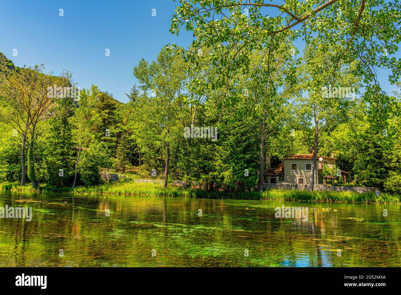 Ferienhaus am See im Schatten von Pflanzen und üppigem Grün. Quellen des Volturno, Rocchetta al Volturno, Isernia, Molise, Italien, Europa Stockfoto