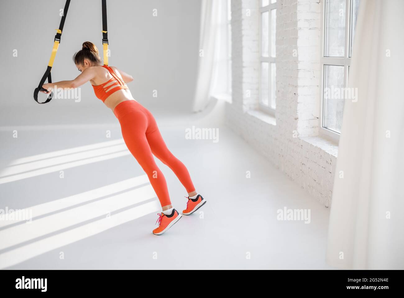 Frau trainiert auf TRX-Fitnessbändern Stockfoto