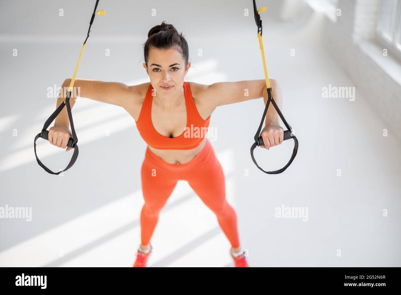 Sportlerin beim Liegestützen auf TRX-Trägern Stockfoto