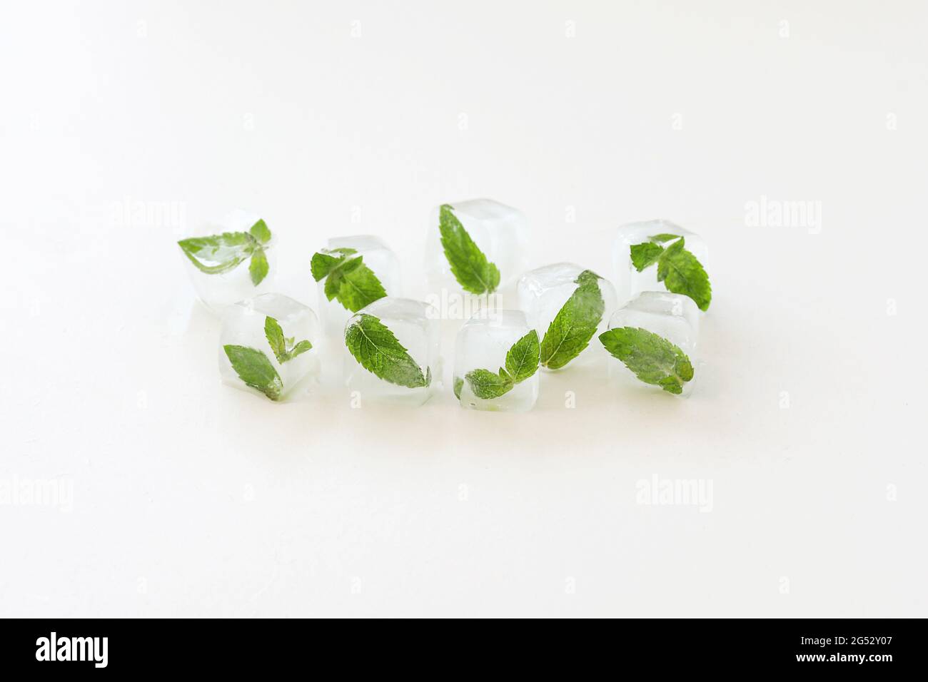 Eiswürfel mit Minzblättern auf weißem Hintergrund. Speicherplatz kopieren. Stockfoto