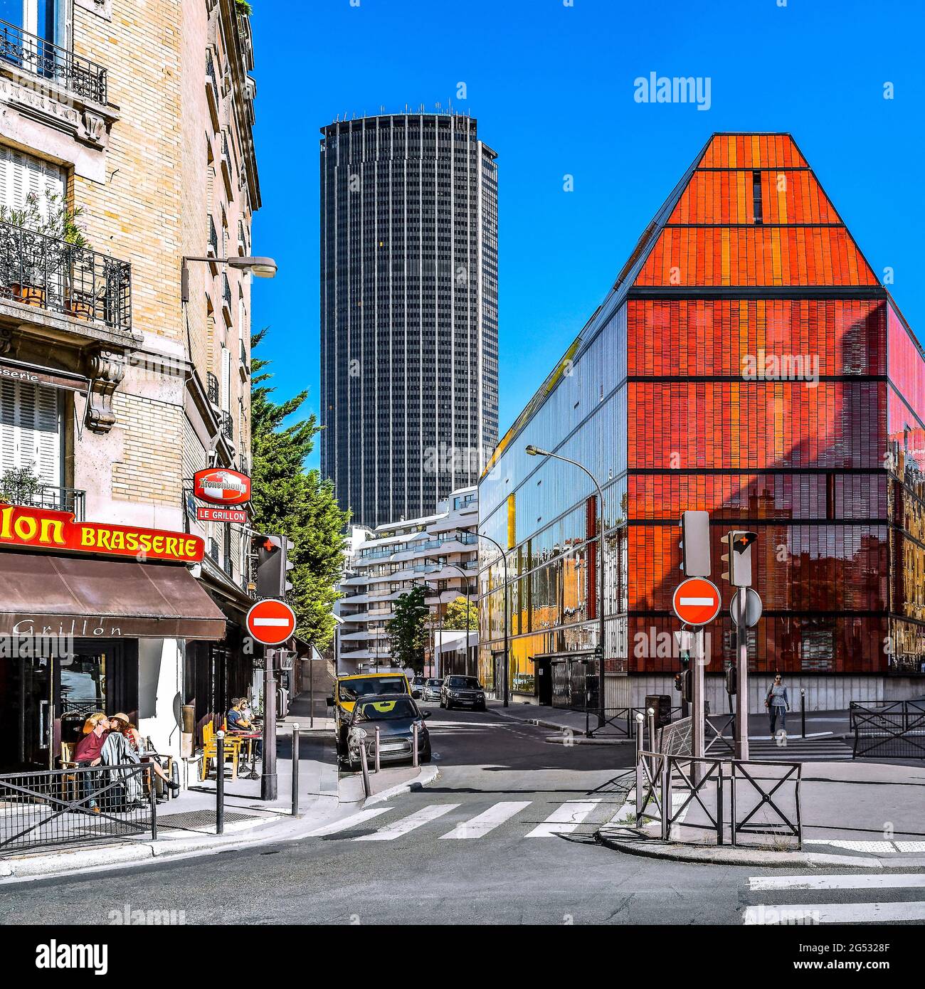 FRANKREICH. PARIS (75) PAAR KÜSST SICH AUF DER TERRASSE EINES BISTROS VOR DEM MODERNEN GEBÄUDE DER NOVANCIA BUSINESS SCHOOL, DEM MONTPARNASSE TOWER I Stockfoto