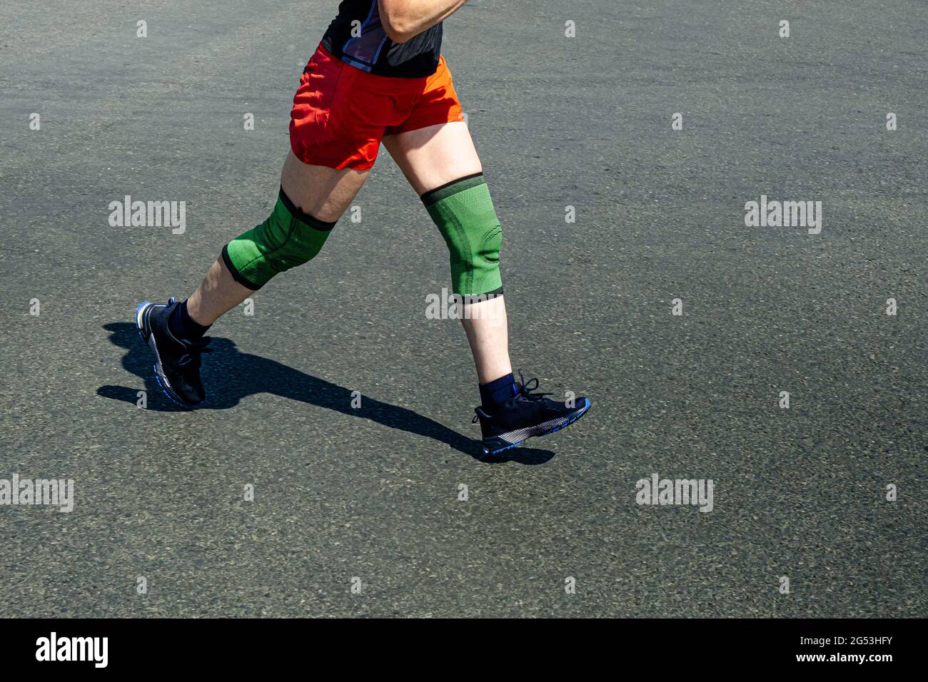 Beine Ältere weibliche Läuferin in Kniepolstern Rennen Stockfoto