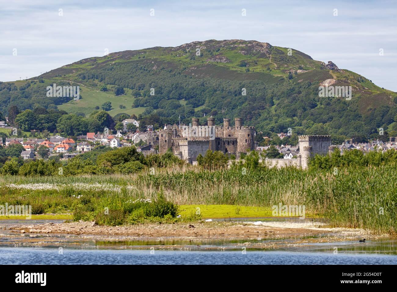 Blick über den Fluss Conwy auf Conwy Castle mit dem Metallbahntunnel, der in der Szene sichtbar ist. Stockfoto