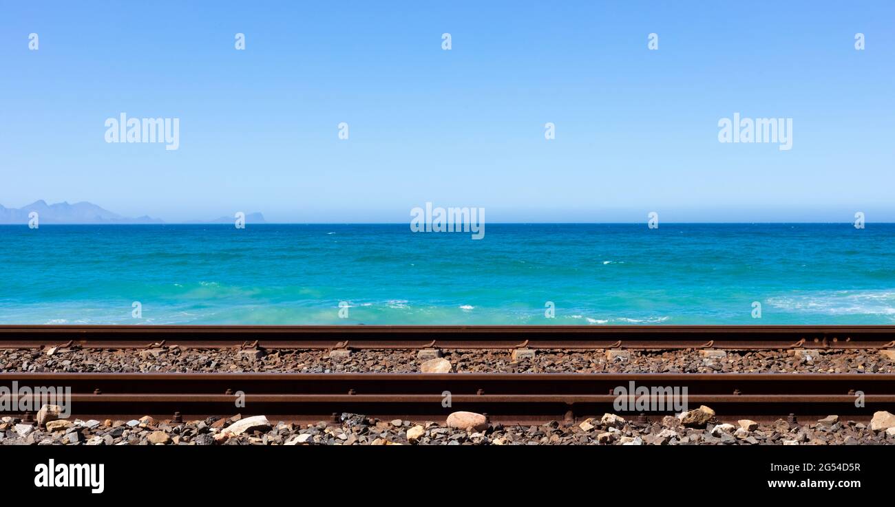 Die Passagiereisenbahnlinie verläuft neben der Küste von False Bay in Kapstadt Stockfoto
