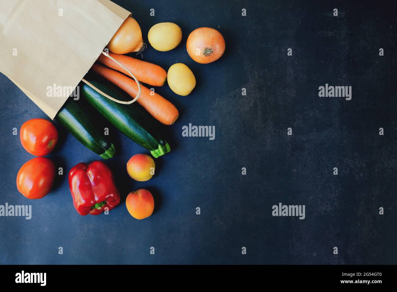 Einkaufen oder liefern gesunde Lebensmittel Konzept. Lebensmittelmarkt und sauberes veganes Esskonzept. Frisches Gemüse, Obst: In Papiertüte auf schwarzem Hintergrund Stockfoto