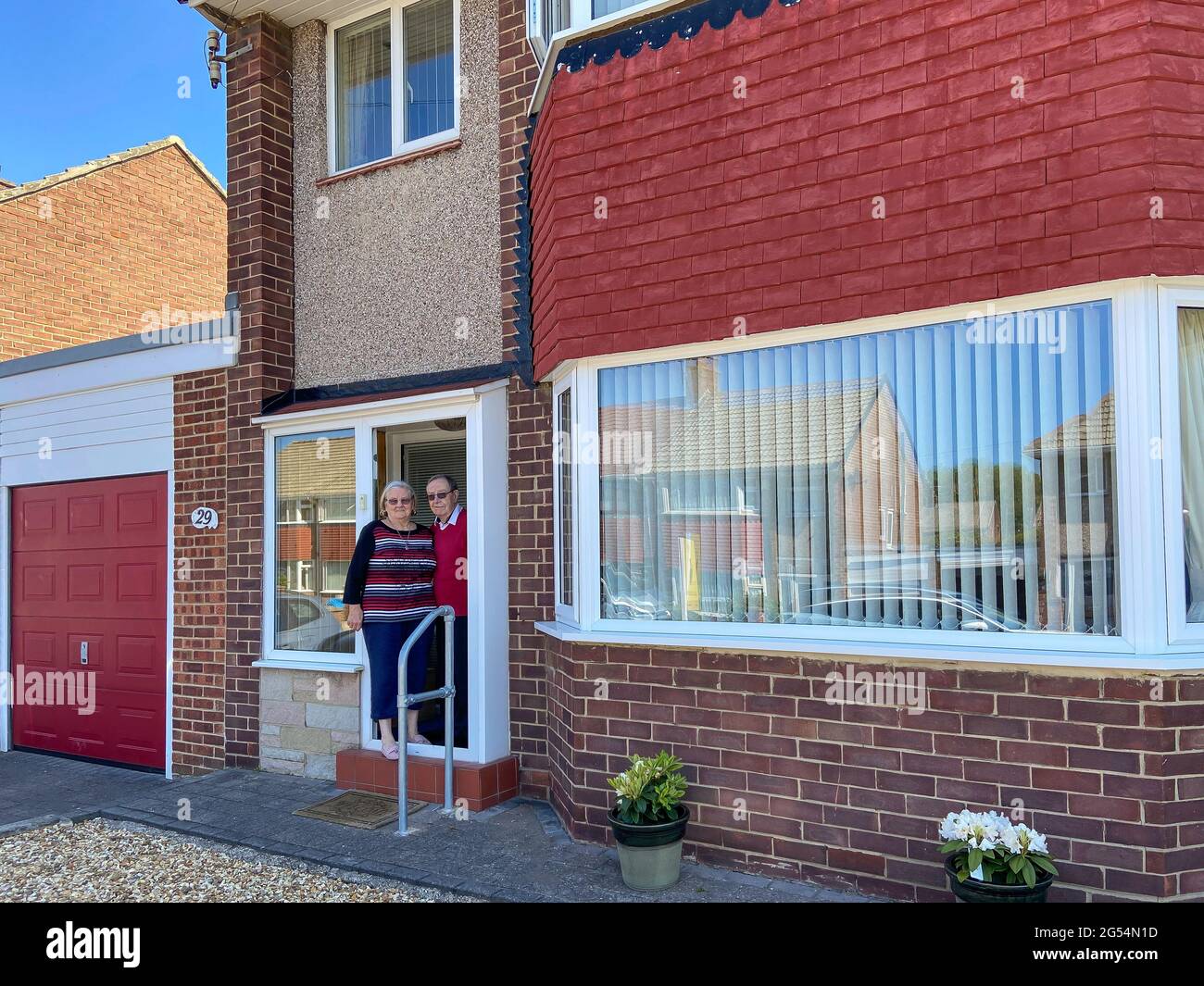 Das elderley-Paar, das vor dem Eingang ihres Doppelhauses, St. Christopher's Place, Sunderland, Tyne and Wear, England, steht, Vereinigtes Königreich Stockfoto