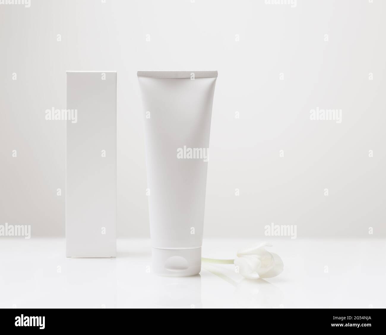 Beauty-Produkt, Kosmetik, Hygiene-Mockup für Ihr Design und Label. Weiße Kosmetikröhre und Box aus Kunststoff mit Reflexion auf weißem Hintergrund Stockfoto
