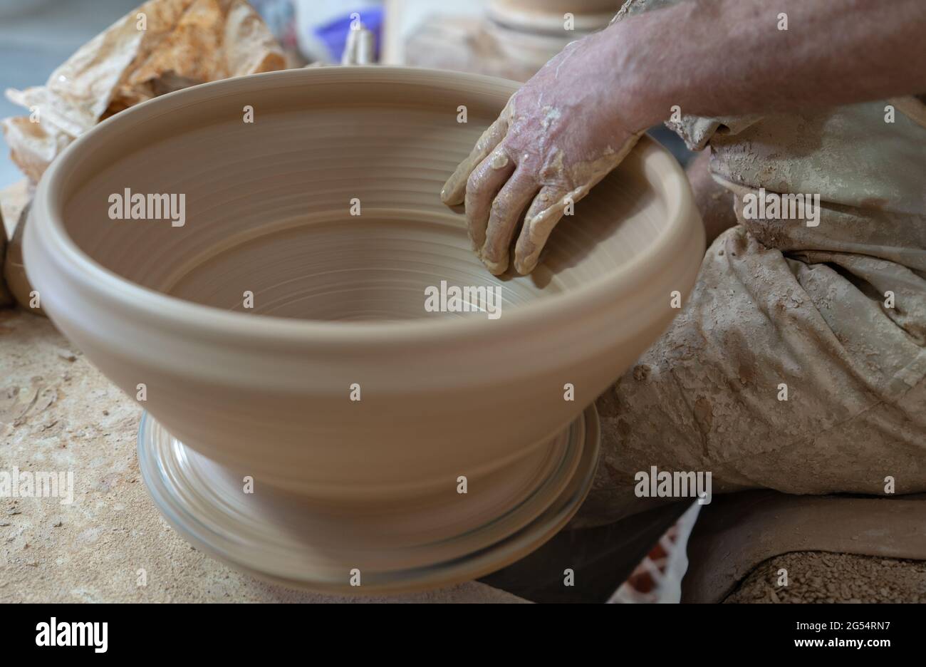 Potter arbeitet sanft mit der Hand auf dem Topf Stockfoto