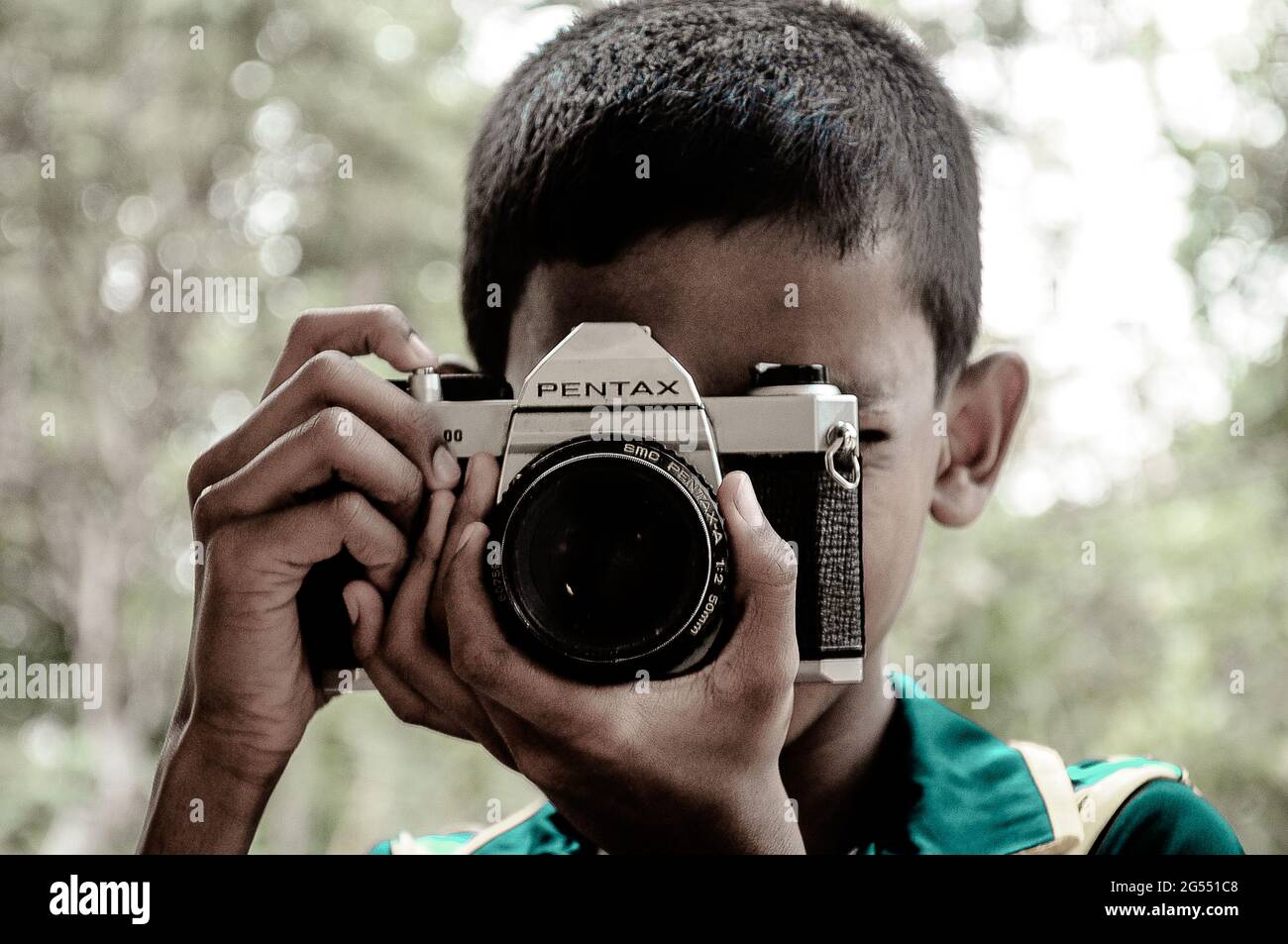Ein Kind mit einer alten pentax-Kamera. Ich nehme dieses Bild in srilanka auf, es ist ein sehr schöner Moment. Stockfoto