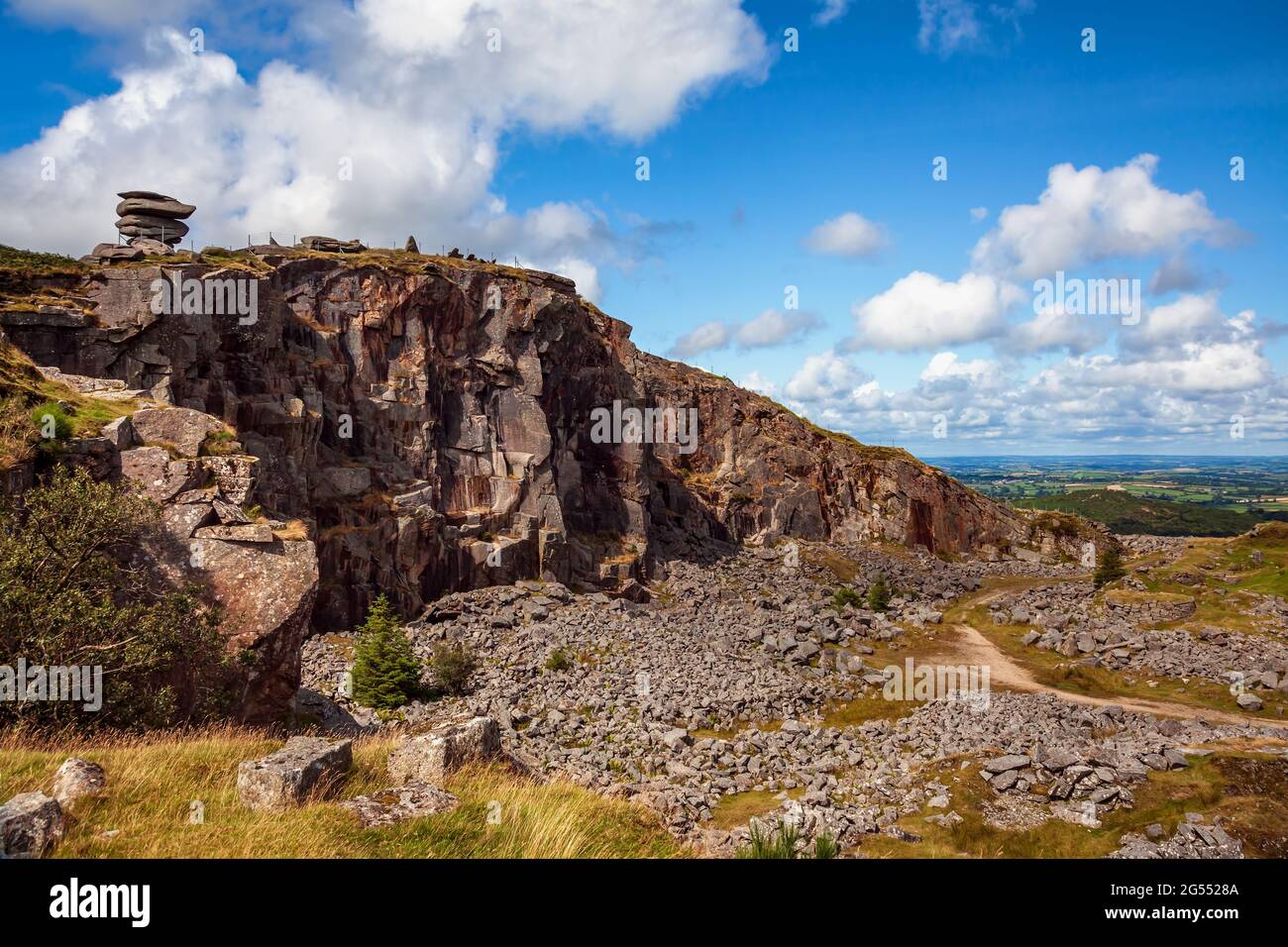 Die natürliche Gesteinsformation „Cheesewring“ scheint über den stillgeratenen Steinbruch „Cheesewring Quarry“ auf Stowe's Hill, Bodmin Moor in Cornwall, prekär ausgeglichen zu sein. Stockfoto