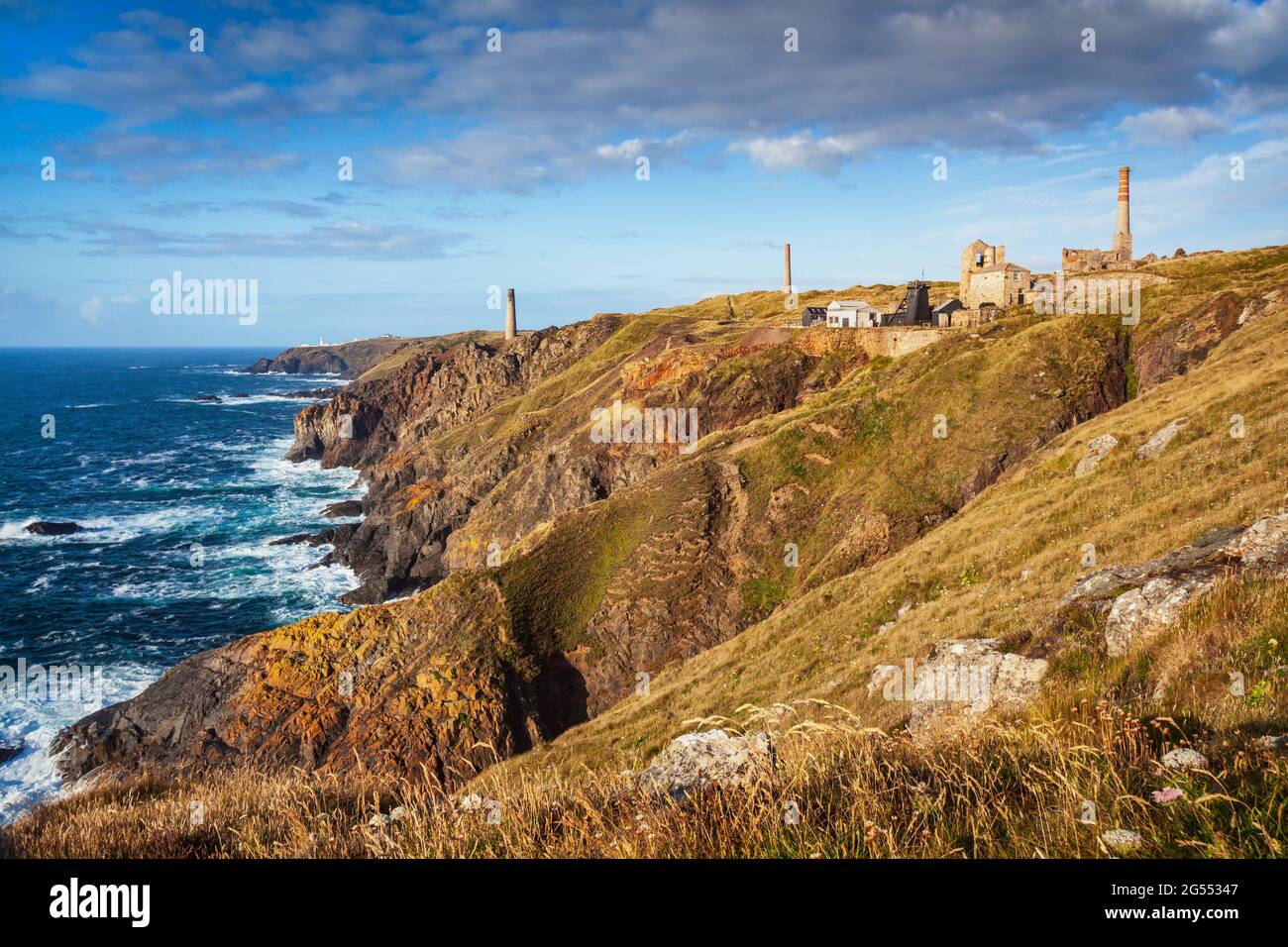 Levant Mine und cornish Motorhäuser, mit dem Pendeen Leuchtturm in der Ferne, in der Nähe von Pendeen in Cornwall. Stockfoto