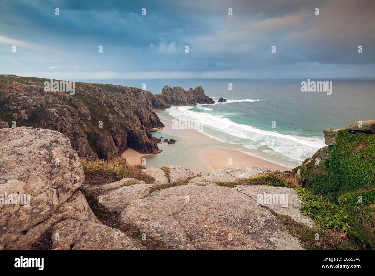 Blick vom Treen Cliff über den Pendvounder Beach in der Nähe von Porthcurno in Cornwall an einem stürmischen Sommermorgen, mit der Landzunge von Treryn Dinas in der Ferne Stockfoto