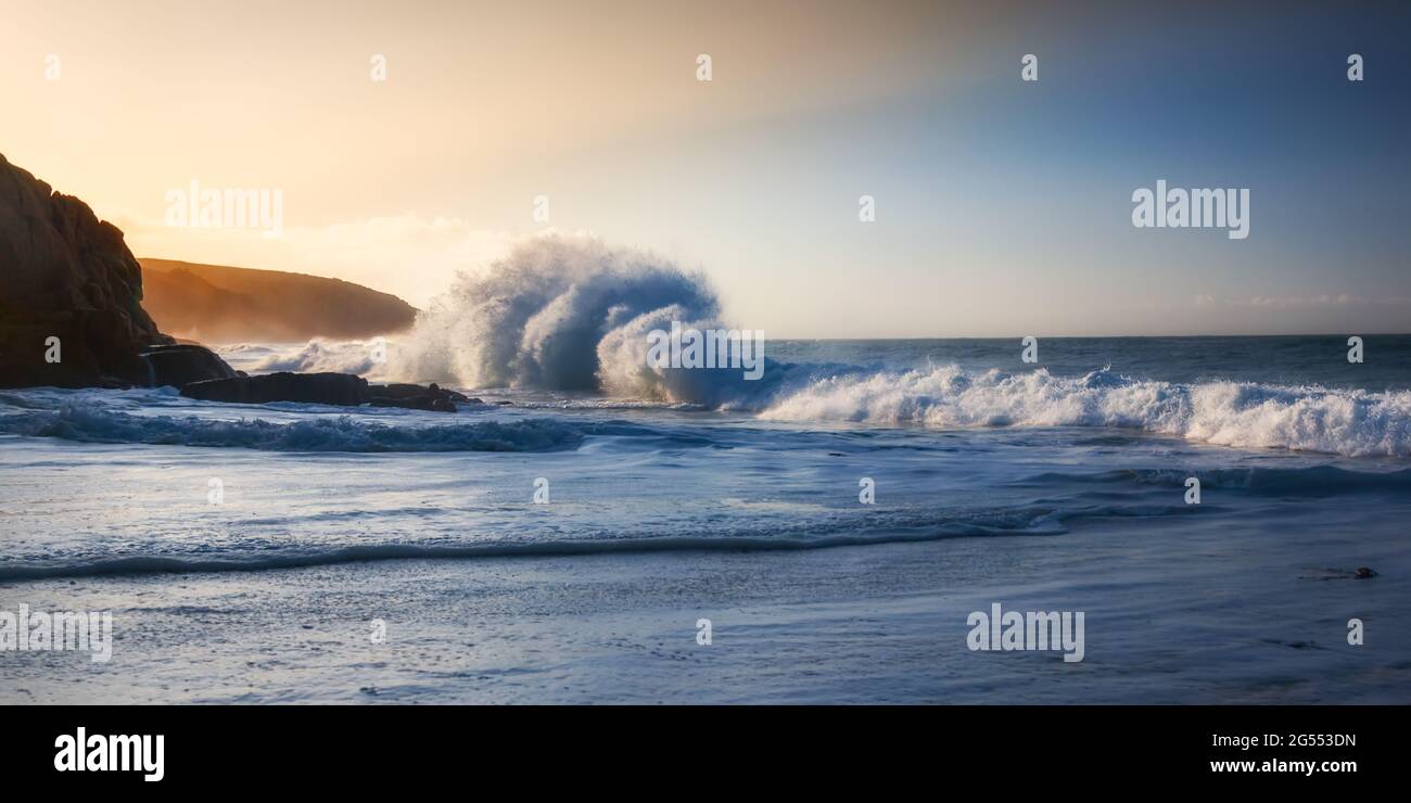 An einem hellen Sommermorgen stürzte eine Welle auf den Pednvounder Beach in der Nähe von Porthcurno in Cornwall. Stockfoto
