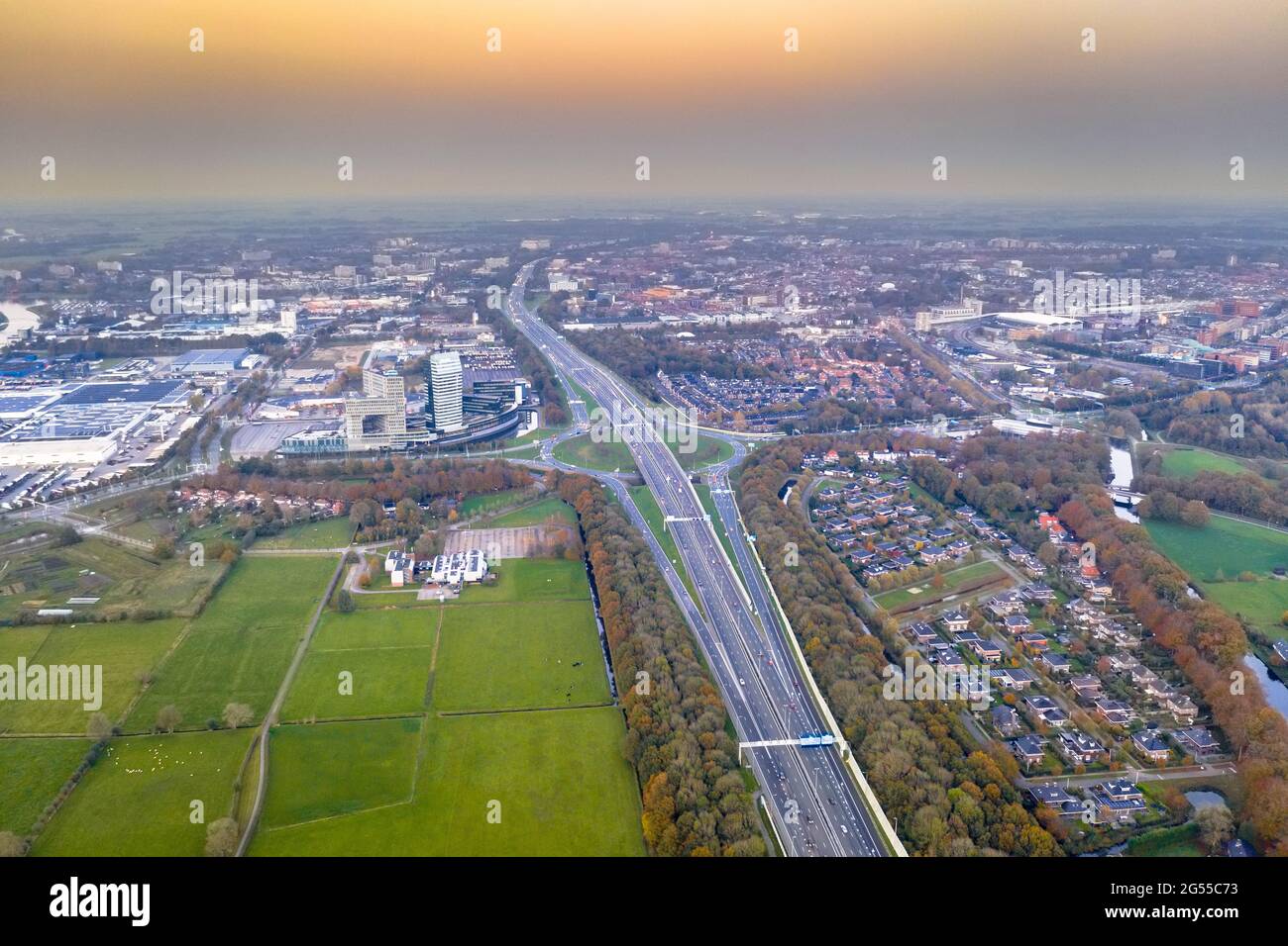 Luftaufnahme der Autobahn durch die Stadt Zwolle bei Sonnenuntergang. Provinz Overijssel, Niederlande. Stockfoto